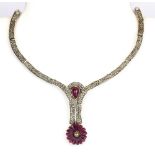 A white metal part necklace set with a cabochon cut ruby and rose cut diamonds, approx. L. 13cm.