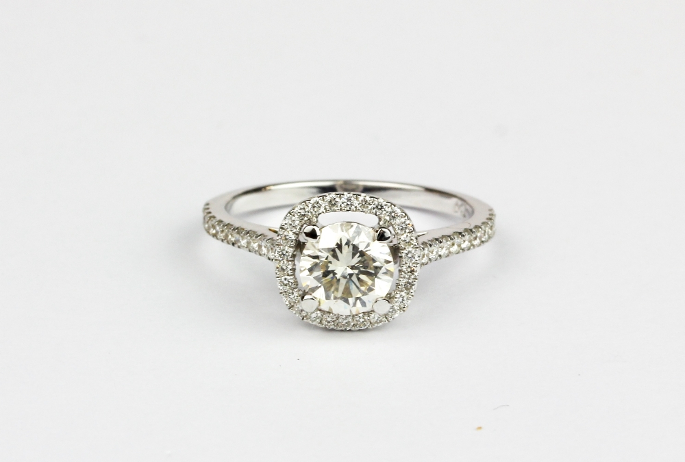 A 18ct white gold (stamped 750) halo ring set with a brilliant cut diamond and diamond set