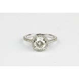 A 18ct white gold (stamped 750) halo ring set with a brilliant cut diamond and diamond set