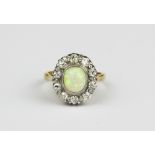 A yellow and white metal (tested minimum 9ct gold) cluster ring set with a cabochon cut opal