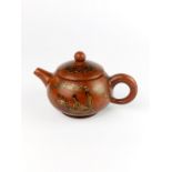 A small Chinese Yixing terracotta teapot with erotic decoration, H. 7.5. spout to handle 12cm.