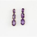 A pair of 9ct yellow gold drop earrings set with three graduated oval cut amethyst, L. 1.7cm.