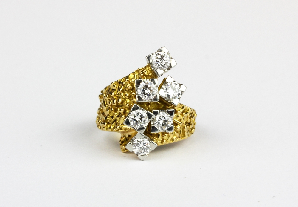 A heavy yellow metal (tested 18ct gold) crossover ring set with six brilliant cut diamonds,