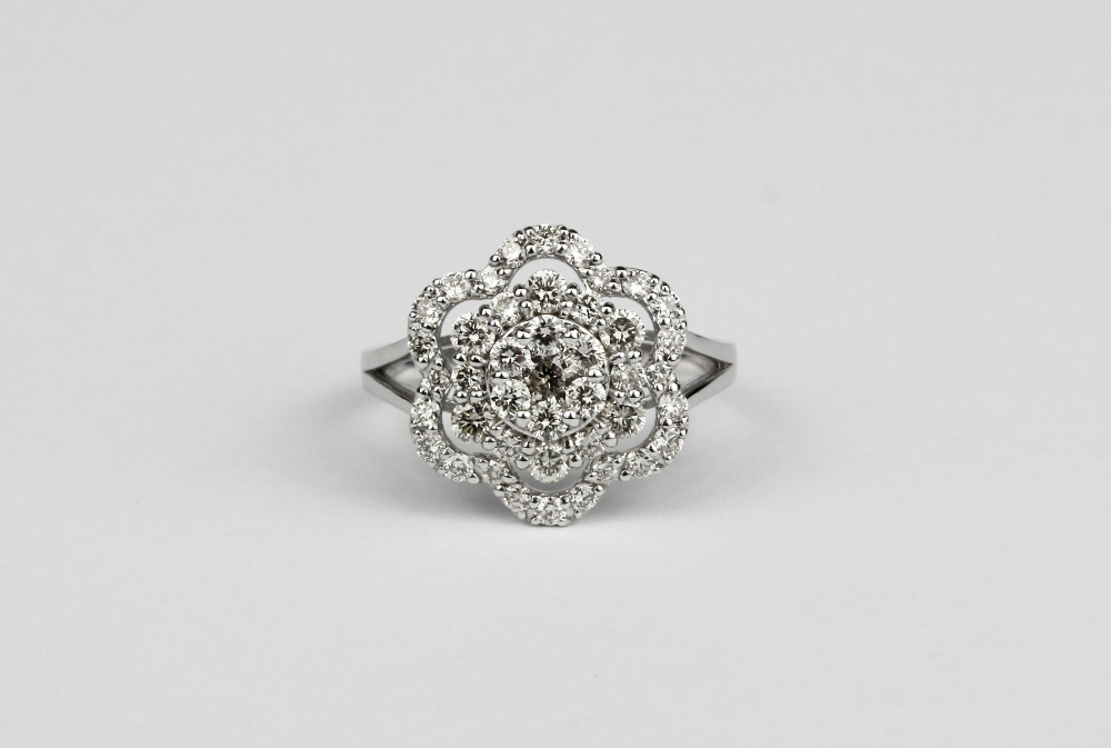 A 18ct white gold (stamped k18) flower shaped cluster ring set with brilliant cut diamonds,