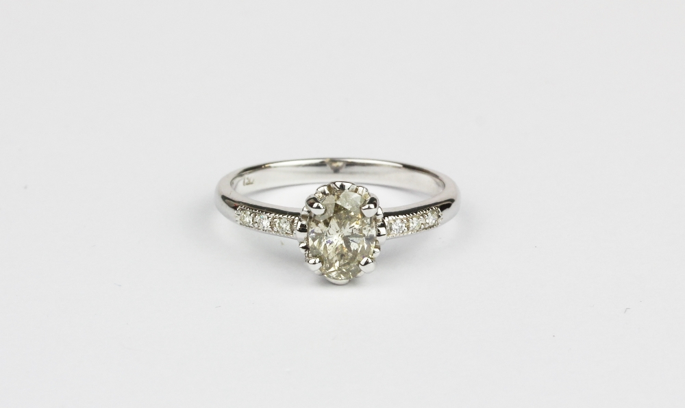 An 18ct white gold (worn stamp 750) ring set with an oval cut brilliant cut diamond and diamond