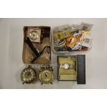 A quantitiy of mixed clocks, watches and badges.