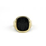 A yellow metal (tested minimum 9ct gold) carved onyx gentleman's signet ring, (W.5).