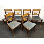 A set of six regency style inlaid mahogany sabre leg dining chairs.