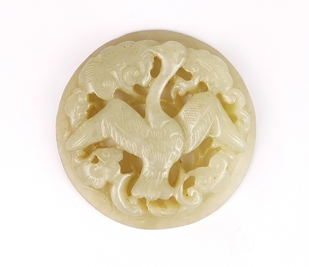 A 19th / 20th Century Chinese carved celadon jade panel of a phoenix in clouds, Dia. 5.5.cm.