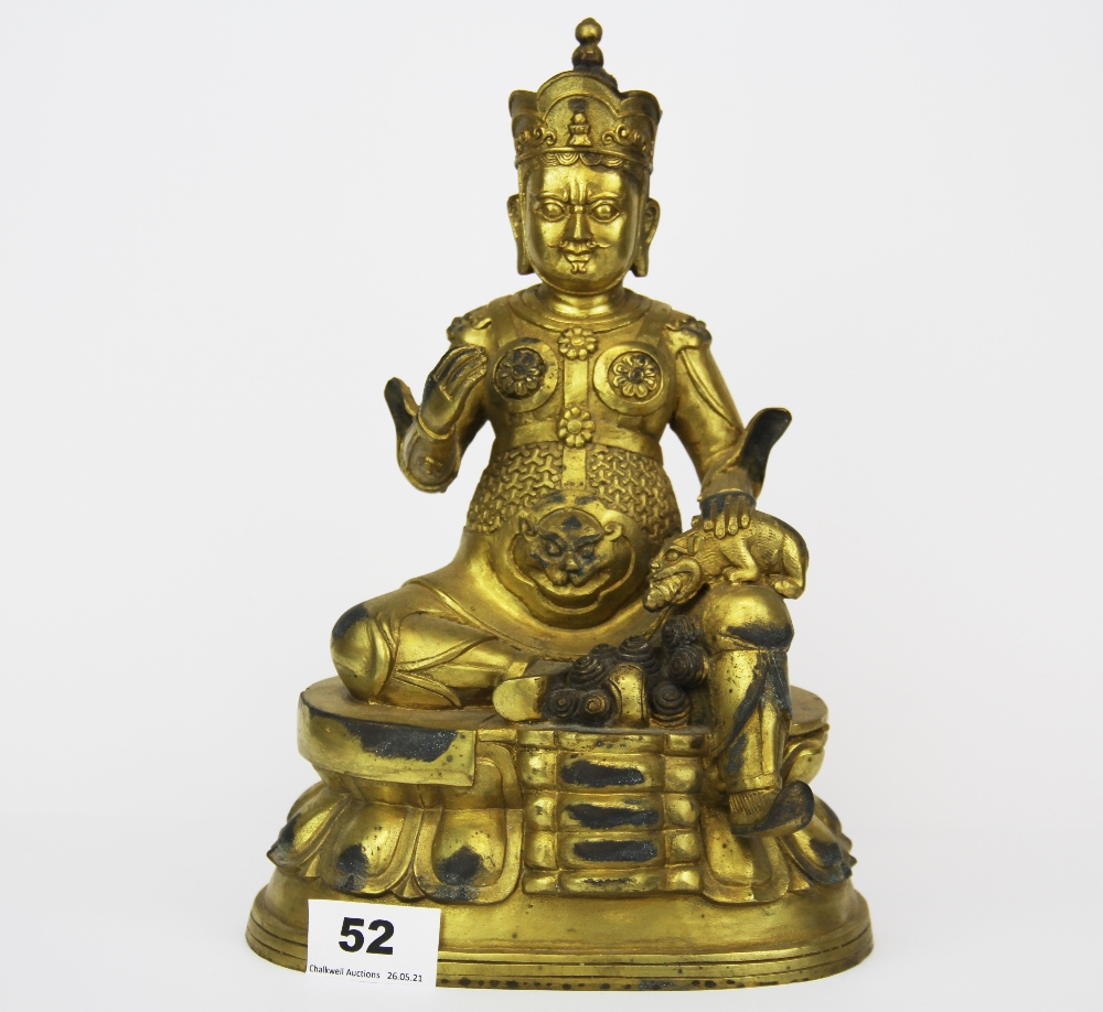 A Tibetan gilt bronze figure of a seated Buddhist Deity, H. 26cm.