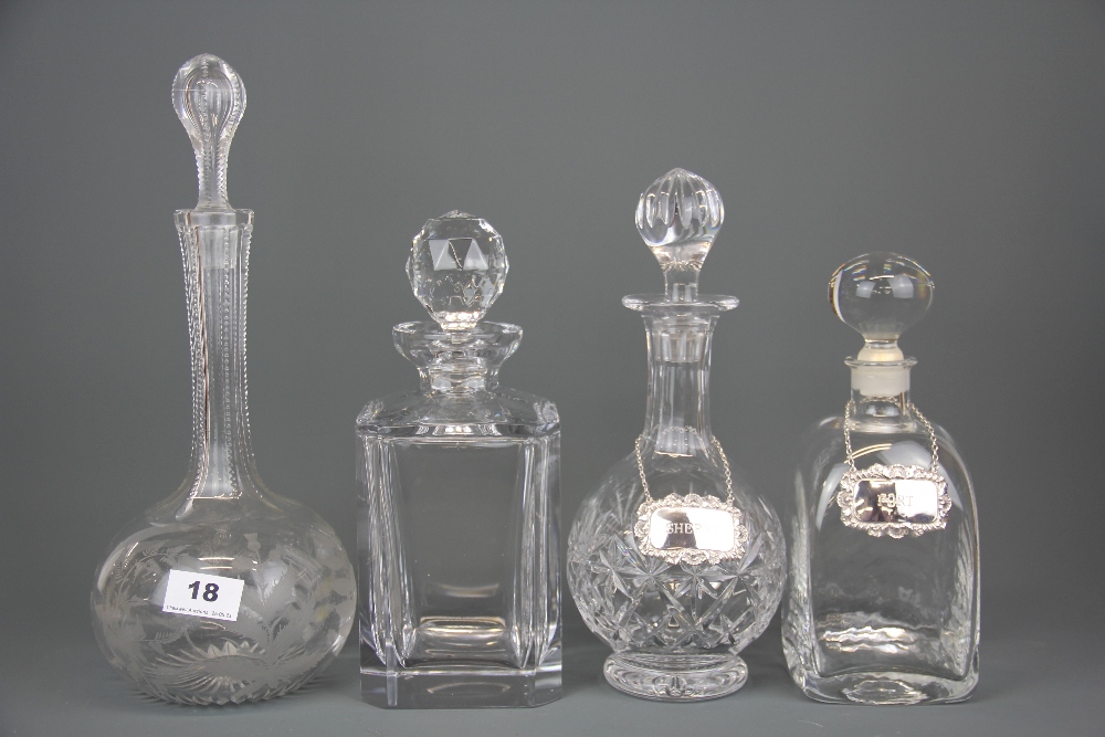 Three cut crystal decanters and a further glass decanter together with two hallmarked silver labels,