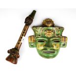 Two South American glazed pottery items in the style of the Inca mask and flute, flute length 34cm.