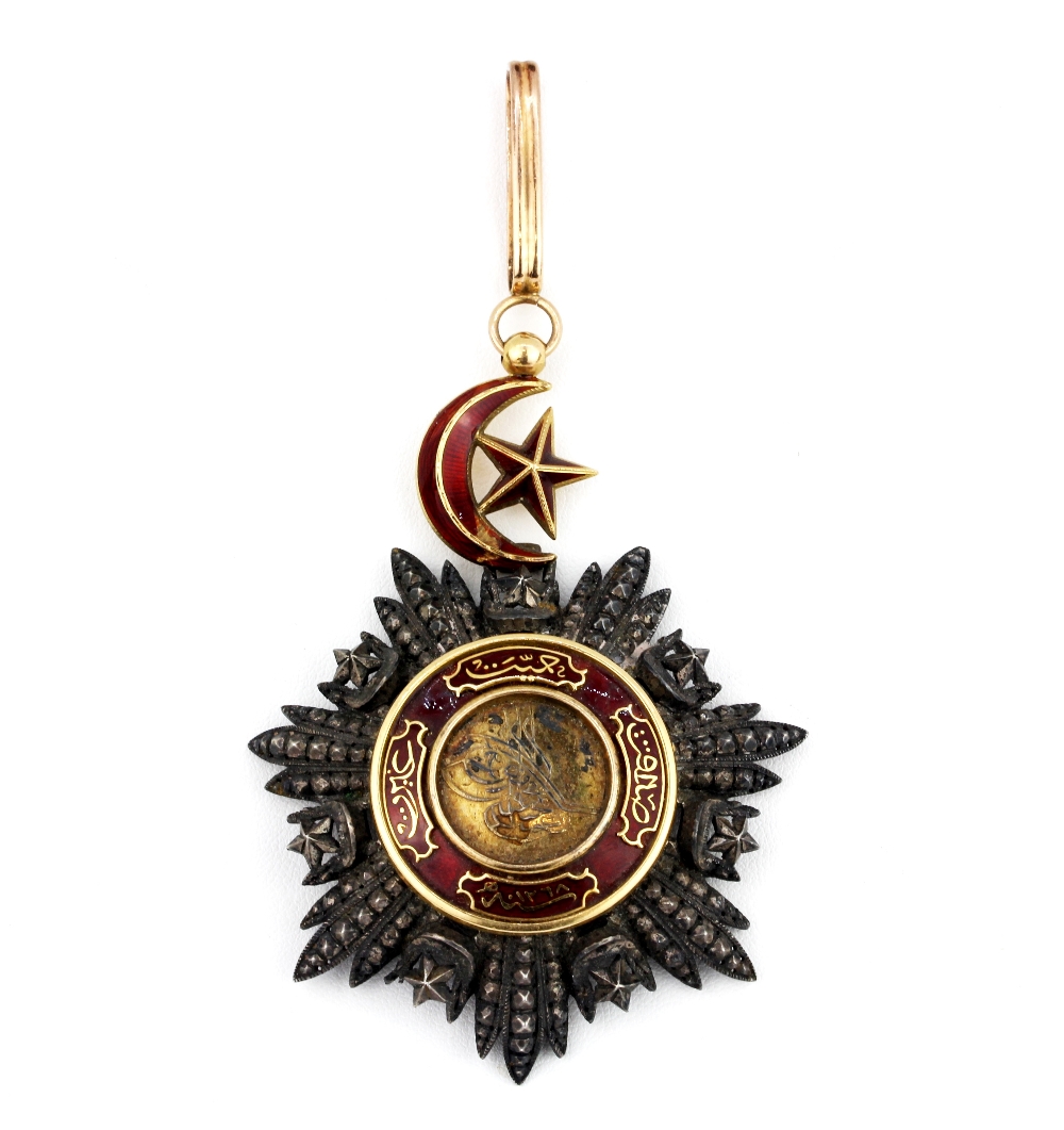 Islamic interest. A yellow and white metal (tested gold and silver) enamelled pendant decorated with