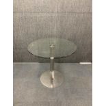 A glass and stainless steel circular table, dia. 80cm, H. 74cm.