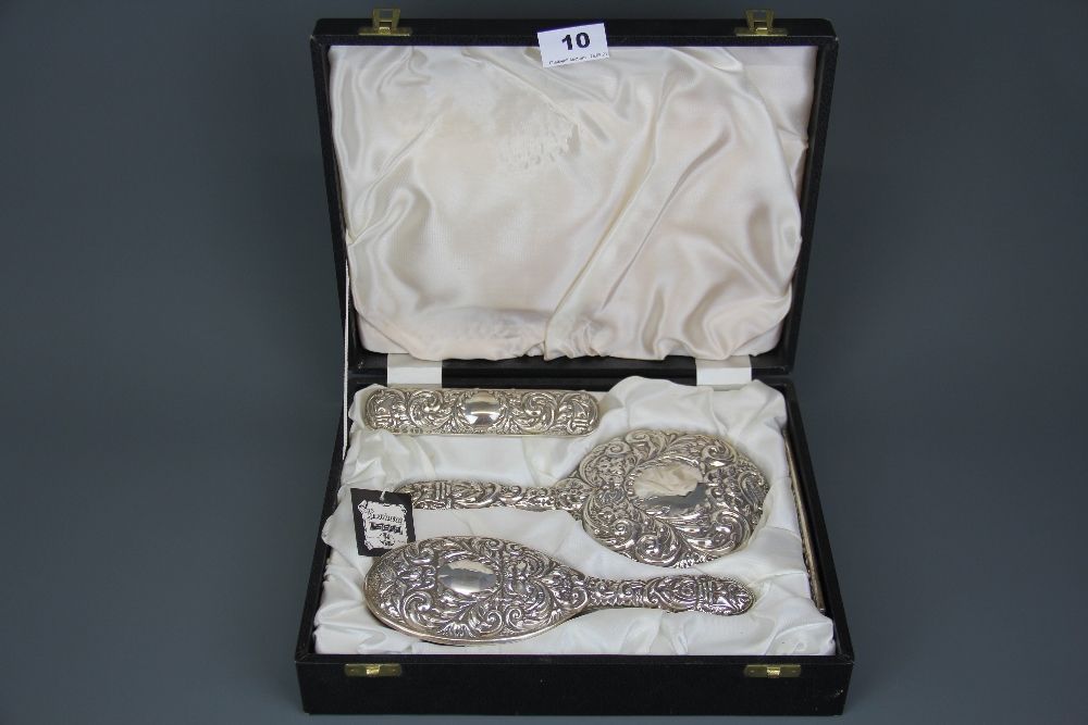 A boxed four piece hallmarked silver dressing table set.