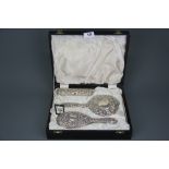 A boxed four piece hallmarked silver dressing table set.