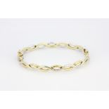 A 9ct yellow and white gold (stamped 375) bangle, Dia. 6.5cm.