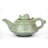 A Chinese celadon glazed relief decorated red clay pottery tea pot, H. 11cm. Spout to handle 20cm.