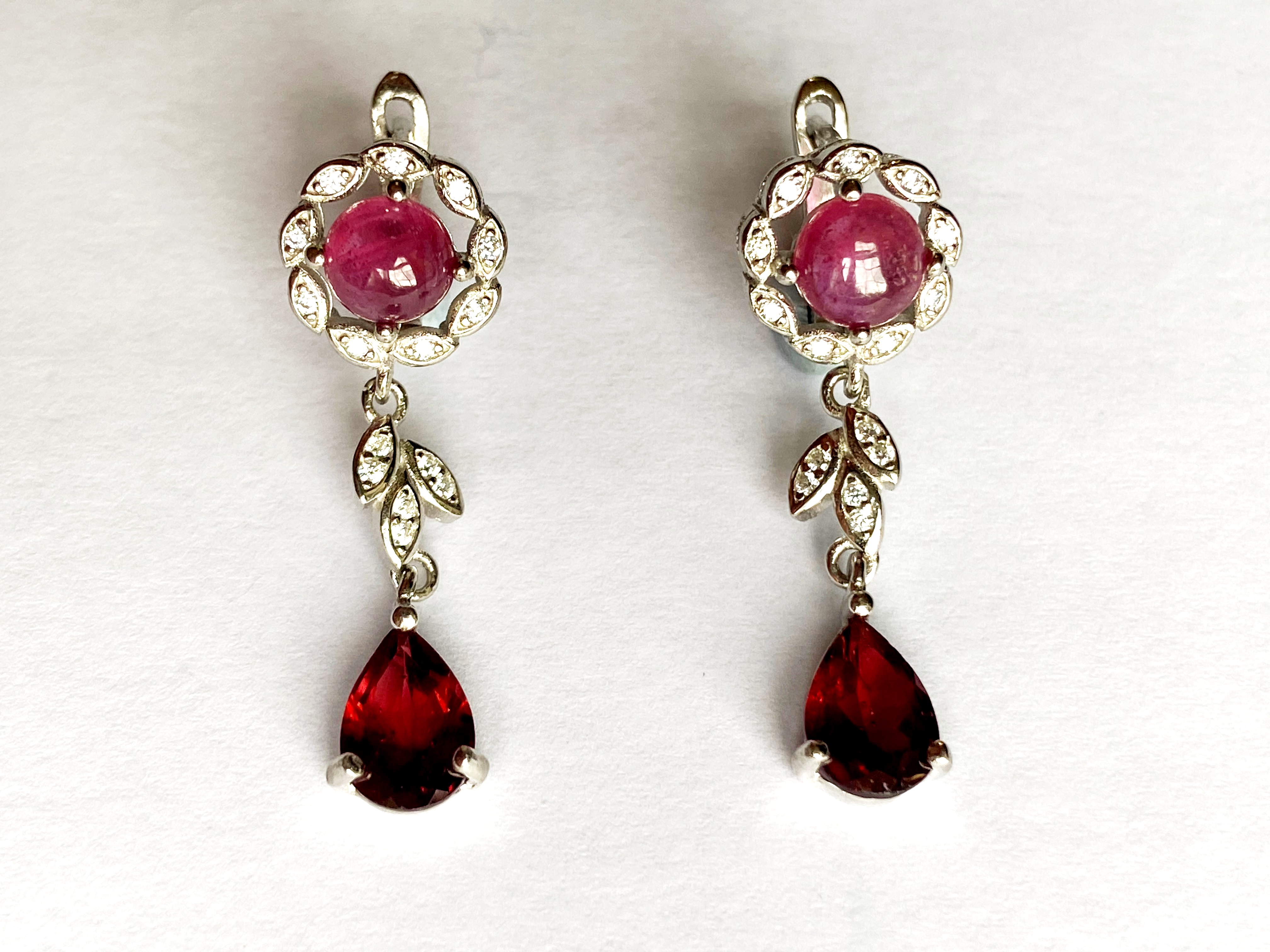A pair 925 silver drop earrings set with cabochon cut rubies and pear cut garnets, L. 3.2cm.