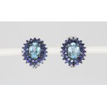 A pair of 925 silver earrings set with an oval cut blue topaz and two rows of sapphires, L. 1.7cm.