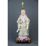 A large Chinese hand painted porcelain figural table lamp on a carved wooden base, overall H. 48cm.