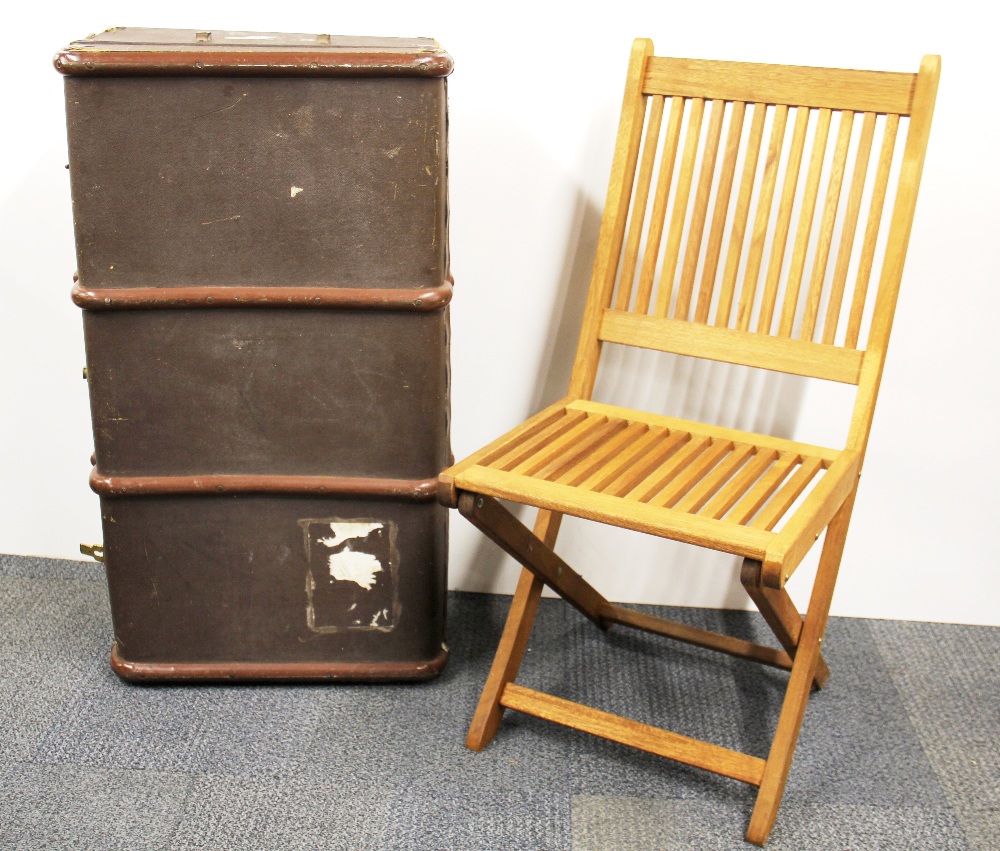 A vintage cabin trunk and folding chair.