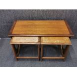 A G-plan type teak coffee table and two nest tables beneath, W. 99cm. H. 52cm.