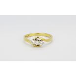 An 18ct yellow gold diamond set crossover ring, (M.5).