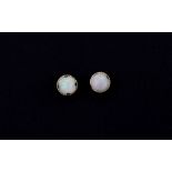 A pair of 9ct yellow gold opal set stud earrings, Dia. 0.6cm.