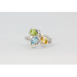 A matching 925 silver ring set with pear cut blue topaz, citrine and peridot, (O).