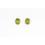 A pair of 9ct yellow gold stud earrings set with oval cut peridots, L. 0.9cm