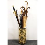 An Oriental porcelain umbrella stand with a collection of walking sticks etc.