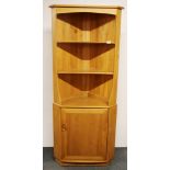 An Ercol light oak corner cabinet, W. 73cm. H. 180cm.