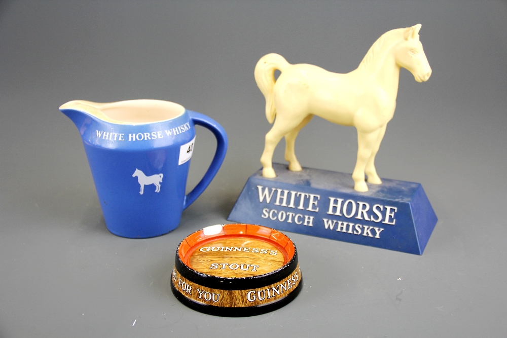 A White Horse Whiskey plastic advertising figure and a White Horse jug together with a Guinness