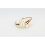 A 9ct yellow gold pearl set crossover ring, (L).