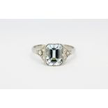 An Art Deco platinum (stamped Plat) ring set with an emerald cut aquamarine and diamond set