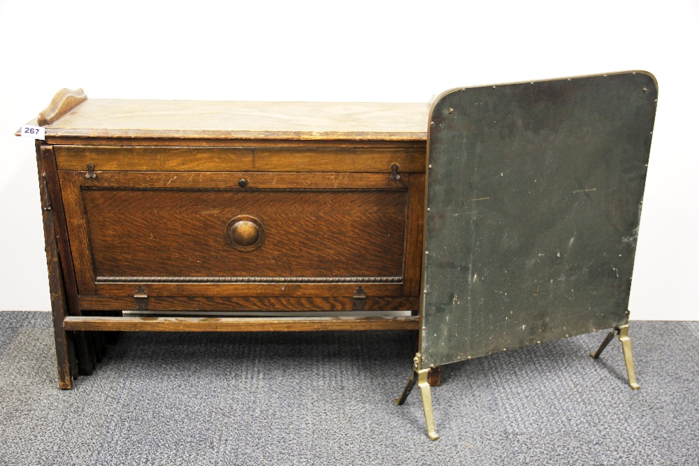 A First World War period oak fold out bed, W. 78cm. together with a brass fire screen.