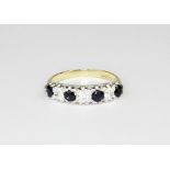 A 9ct yellow gold sapphire and white stone set half eternity ring, (O).
