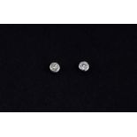 A pair of 9ct white gold (stamped 375) rub over set brilliant cut diamond stud earrings, approx. 0.
