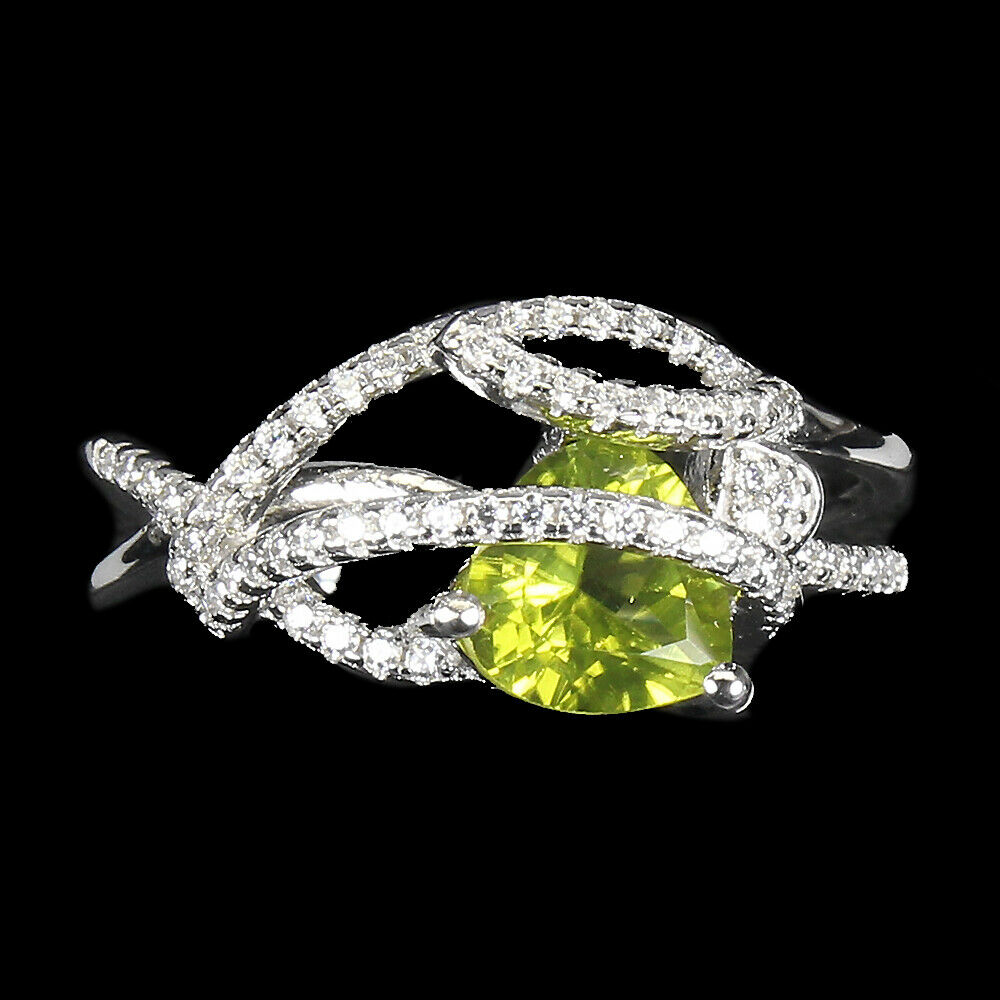 A 925 silver ring set with a trillion cut peridot and white stones, ®.