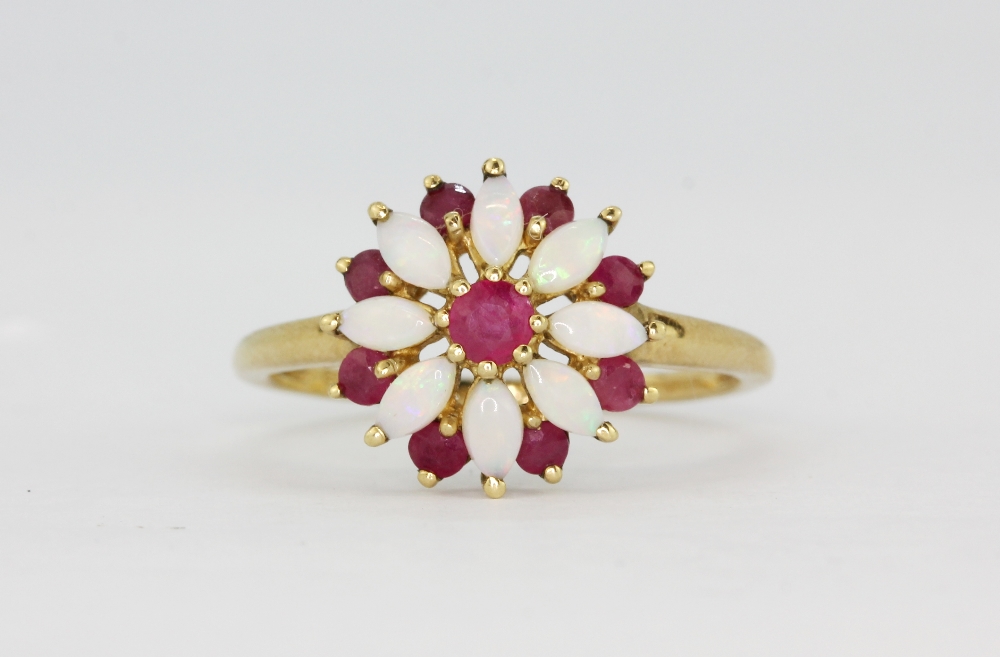 A hallmarked 9ct yellow gold ring set with marquise cabochon cut opals and rubies, (O.5).