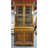 An Art Nouveau carved light oak bookcase over cabinet, H. 235cm, base W. 107cm.