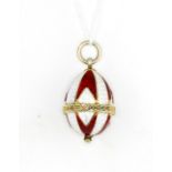 A yellow metal (tested minimum 9ct gold) red and white enamel Faberge egg style pendant, approx.