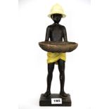 A resin figure of a boy holding a basket, H. 39cm.