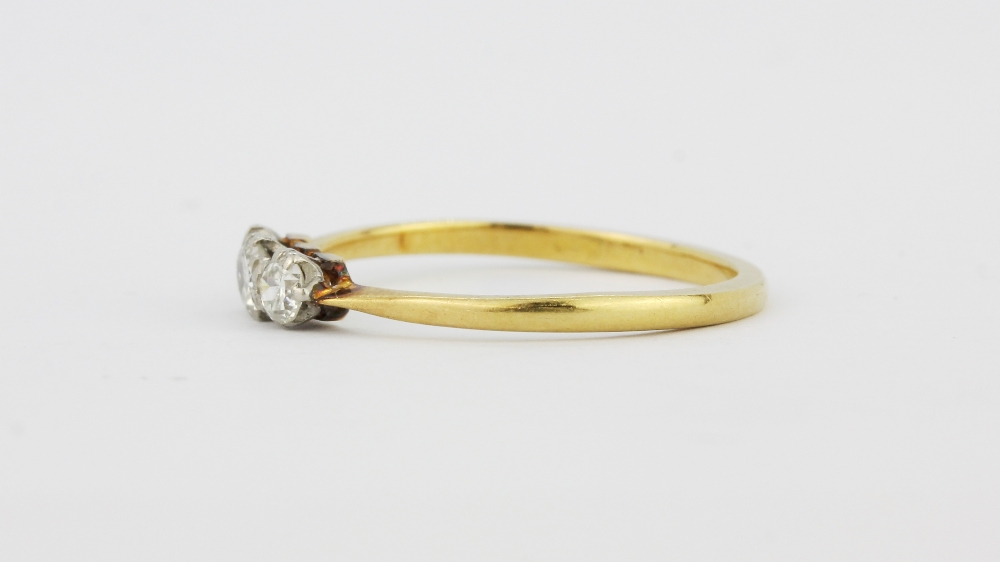 A yellow metal (tested 18ct gold) ring set with three old brilliant cut diamonds, (N.5). - Bild 2 aus 2