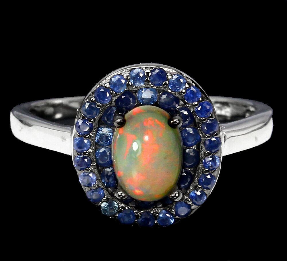 A 925 silver cluster ring set with cabochon cut opal and two rows of sapphires, (O).