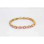 A yellow metal (tested minimum 9ct gold) bracelet set with pink sapphires and pink spinels,