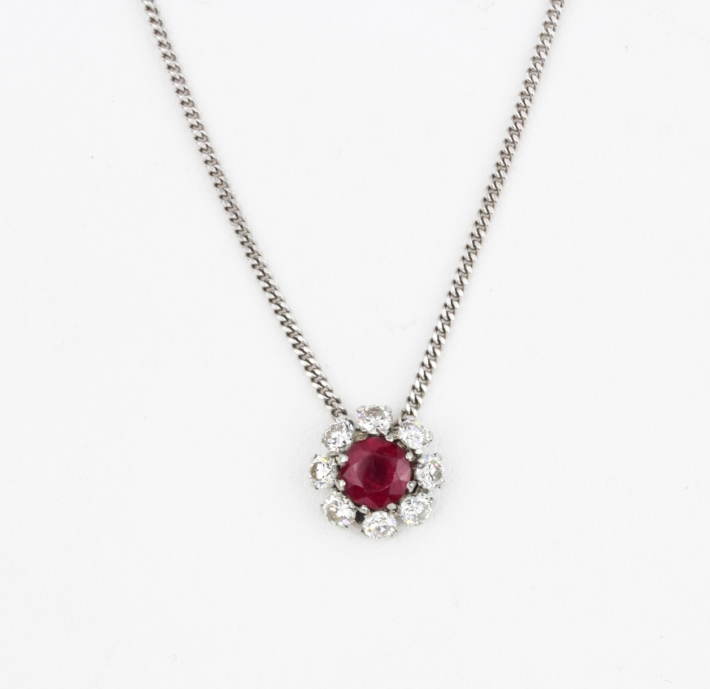 An 18ct white gold (stamped 750) necklace set with a ruby surrounded by brilliant cut diamonds,