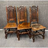 A set of three Jacobean carved oak hall chairs with later loose seat pads, H. 119cm.