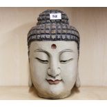 A carved wood and painted Buddha head H. 30cm